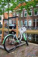 vélo garé près le canal dans delft rue avec vieux Maisons. delft, Pays-Bas photo