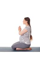 Enceinte femme Faire yoga asana virasana isolé sur blanc photo