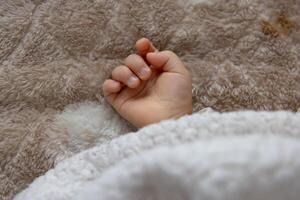 une droite main de en train de dormir asiatique bébé sur le tapis photo