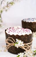 Pâques gâteau décoré avec blanc glaçage et une brin de Cerise fleurs. Christian traditions. fermer. sélectif se concentrer. photo