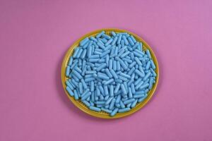 Jaune assiette plein de bleu médicament capsules représentant drogue surdosage photo