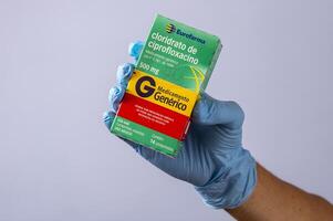rio, brésil - 27 janvier 2023, main avec gant de protection en caoutchouc tenant une boîte à médicaments, chlorhydrate de cipofloxacine photo