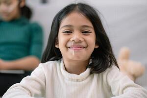 une Jeune fille avec une blanc chemise et longue cheveux est souriant photo