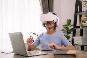 une femme portant une virtuel réalité casque est séance à une bureau avec une portable photo