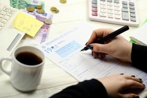 Kyiv, Ukraine - octobre 31, 2023 comptable remplir français impôt forme 2042 le revenu déclaration dans fin de impôt période. Imposition et formalités administratives routine photo