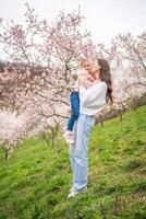 Jeune femme avec peu fille dans une épanouissement rose et blanc jardin pétrin dans Prague, printemps temps dans L'Europe . haute qualité photo