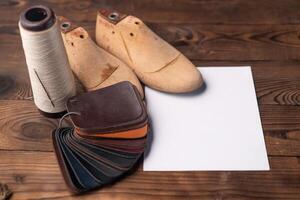cuir échantillons pour des chaussures et en bois chaussure dernier sur foncé en bois tableau. photo