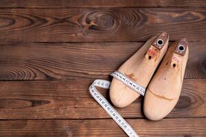 cuir échantillons pour des chaussures et en bois chaussure dernier sur foncé en bois tableau. photo