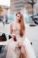 une la mariée dans une mariage robe avec longue cheveux et une boisson bouteille dans le vieux ville de Wroclaw. mariage photo tirer dans le centre de un vieux polonais ville.wroclaw, Pologne