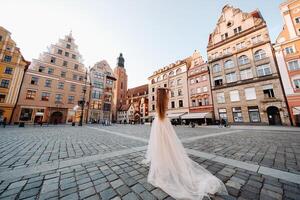 une la mariée dans une mariage robe avec longue cheveux dans le vieux ville de Wroclaw. mariage photo tirer dans le centre de un ancien ville dans Pologne.Wroclaw, Pologne