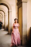 une Jeune magnifique la mariée des stands à le centre de le vieux ville de Florence dans Italie. la mariée dans une magnifique rose robe dans toscane.italie photo