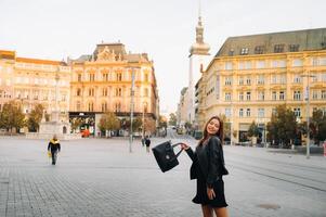 élégant Jeune fille dans une noir robe et veste dans le vieux ville de Brno. tchèque photo