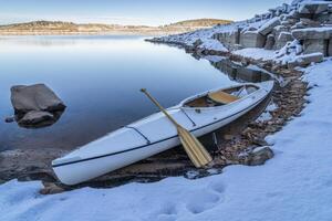 paré expédition canoë sur une rive de charretier Lac dans nord Colorado dans hiver paysage photo