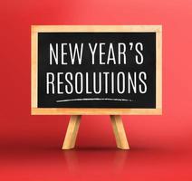 mot de résolutions du nouvel an sur tableau noir avec chevalet sur rouge vif photo