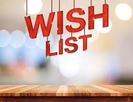 Liste de souhaits mot suspendu au-dessus d'une table en bois avec un arrière-plan clair flou abstrait bokeh photo