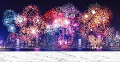 bonne année feux d'artifice sur paysage urbain la nuit avec table de marlbe blanc vide photo