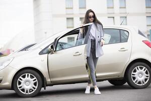 une Jeune fille obtient en dehors de le auto. femme dans le ville à le voiture photo