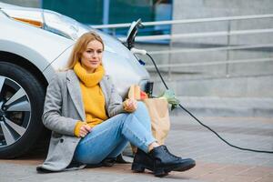 mise en charge électro voiture à le électrique gaz gare. femme par le voiture photo