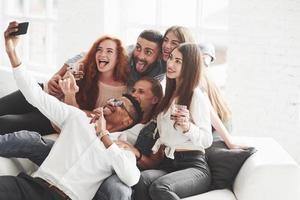 visages heureux. groupe de coéquipiers multiraciaux s'amusant pendant leur pause et prenant des photos