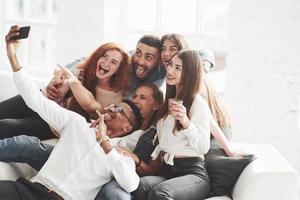 ambiance joyeuse. groupe de coéquipiers multiraciaux s'amusant pendant leur pause et prenant des photos