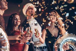 jetez un oeil à ces confettis. photo de la compagnie d'amis faisant la fête avec de l'alcool