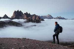 en regardant le puissant pouvoir de la nature. voyageur fatigué en train de capturer la montagne, faisant une pause après une longue marche et une escalade au sommet photo