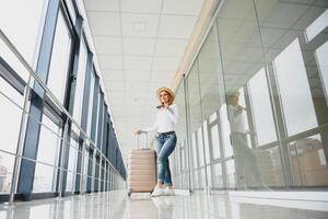 femme en marchant avec valise sur le aéroport terminal, voyage concept. haute saison et vacances concept. se détendre et modes de vie. Voyage et vacances concept. photo