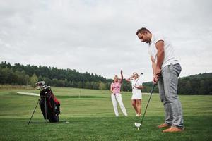 groupe d'amis élégants sur le terrain de golf apprennent à jouer à un nouveau jeu