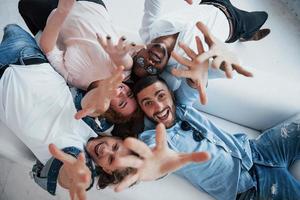 ils veulent vous joindre. jeunes allongés et souriants à la caméra photo