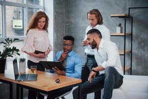 remue-méninges, en pensant à résoudre le problème. groupe d'employés de bureau multiraciaux en vêtements formels parlant de tâches et de plans photo