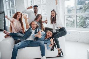 faire la fête avec des camarades. jeunes amis joyeux s'amusant et buvant dans l'intérieur blanc photo