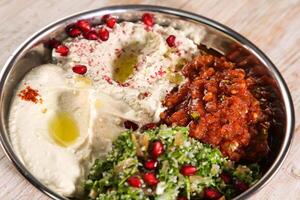 classique mezza plat avec baba ganoujm, turc salsa, Labné, taboula servi dans plat isolé sur Contexte Haut de arabe nourriture du froid mezza photo