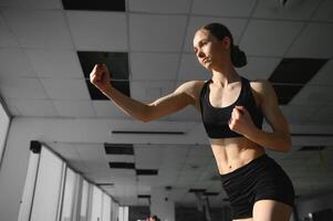 boxe femme pendant exercice-gris Contexte à Gym photo