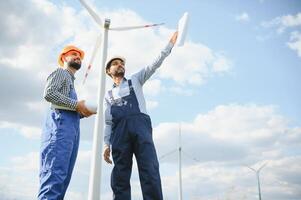 deux ingénieurs discuter contre turbines sur vent turbine cultiver. photo