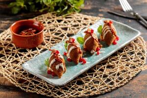 kibbeh ou kibe, quibe, kibbe avec mayo plonger, Chili sauce et Grenade des graines servi dans plat isolé sur table Haut vue de arabe petit déjeuner photo