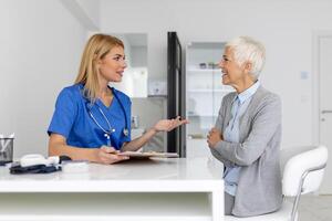 soins de santé et médical concept - médecin avec patient dans hôpital. médecin travail dans le Bureau et écoute à le patient, elle est expliquant sa symptômes, santé se soucier et assistance concept photo