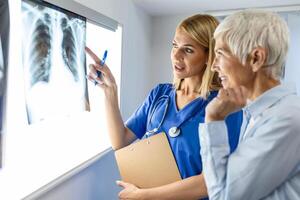radiologie et médicament concept. médecin expliquant le résultats de analyse poumon sur écran à Sénior patient. photo