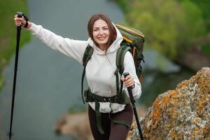 Jeune femme avec sac à dos randonnée dans le montagnes. randonnée concept. trekking falaises. voyage, voyageur. photo