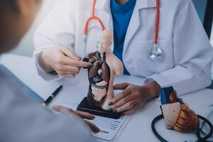 médecin expliquant cœur à personnes âgées patient. médecin expliquant le cœur modèle. médecins stylo point à une modèle de le cœur photo