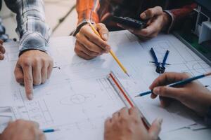 ingénieur gens réunion travail et montrer du doigt à une dessins dans Bureau pour discuter. ingénierie outils et construction concept. photo