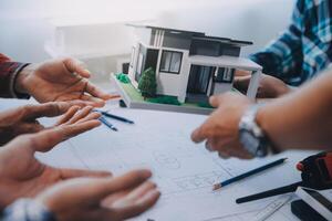 ingénieur gens réunion travail et montrer du doigt à une dessins dans Bureau pour discuter. ingénierie outils et construction concept. photo