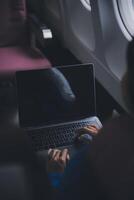 en utilisant mobile et ordinateur portable, réfléchi asiatique gens femelle la personne à bord, avion fenêtre, à la perfection Capturer le anticipation et excitation de vacances Voyage. Chinois, Japonais personnes. photo