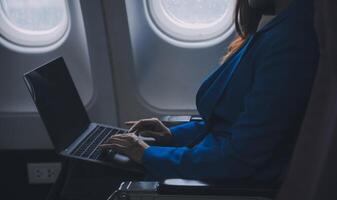 en utilisant mobile et ordinateur portable, réfléchi asiatique gens femelle la personne à bord, avion fenêtre, à la perfection Capturer le anticipation et excitation de vacances Voyage. Chinois, Japonais personnes. photo