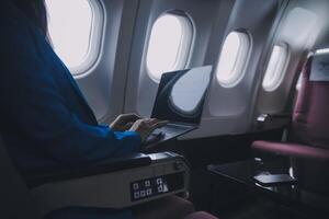 en utilisant mobile et ordinateur portable, réfléchi asiatique gens femelle la personne à bord, avion fenêtre, à la perfection Capturer le anticipation et excitation de vacances Voyage. Chinois, Japonais personnes. photo