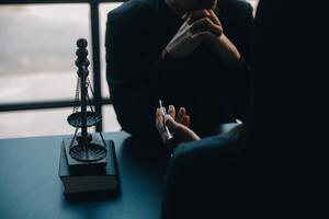 concept de justice et de droit. juge masculin dans une salle d'audience avec le marteau, travaillant avec, clavier d'ordinateur et d'accueil, lunettes, sur table à la lumière du matin photo