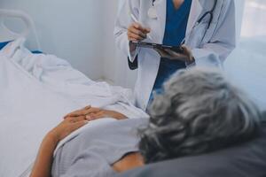 femmes asiatique médecins tenir le patient main et encourager et fournir médical Conseil tandis que vérification le patient santé dans lit. concept de se soucier et compassion, prénatale se soucier, menacé Avortement photo