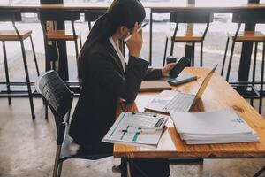 les femmes asiatiques sont stressées en travaillant sur un ordinateur portable, une femme d'affaires asiatique fatiguée avec des maux de tête au bureau, se sentant malade au travail, copiez l'espace photo