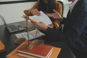 concept de justice et de droit. un conseiller juridique présente au client un contrat signé avec un marteau et un droit juridique ou juridique ayant une réunion d'équipe au cabinet d'avocats en arrière-plan photo