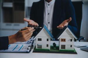 L'agent immobilier a parlé des termes du contrat d'achat de maison et a demandé au client de signer les documents pour conclure le contrat légalement, les ventes de maisons et le concept d'assurance habitation. photo