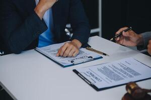 consultation et conférence d'avocats masculins et de femmes d'affaires professionnelles travaillant et discutant dans un cabinet d'avocats en fonction. notions de droit, marteau de juge avec balance de justice. photo